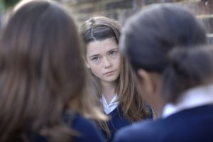 Two girls bullying other school girl
